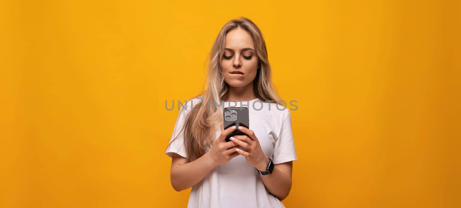 girl with a gadget sits on the Internet on an orange background.