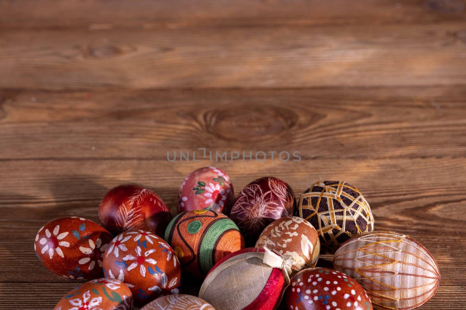 Easter composition of several Easter eggs with brown tones arranged on old brown boards. Blank bowl for adding inscriptions.