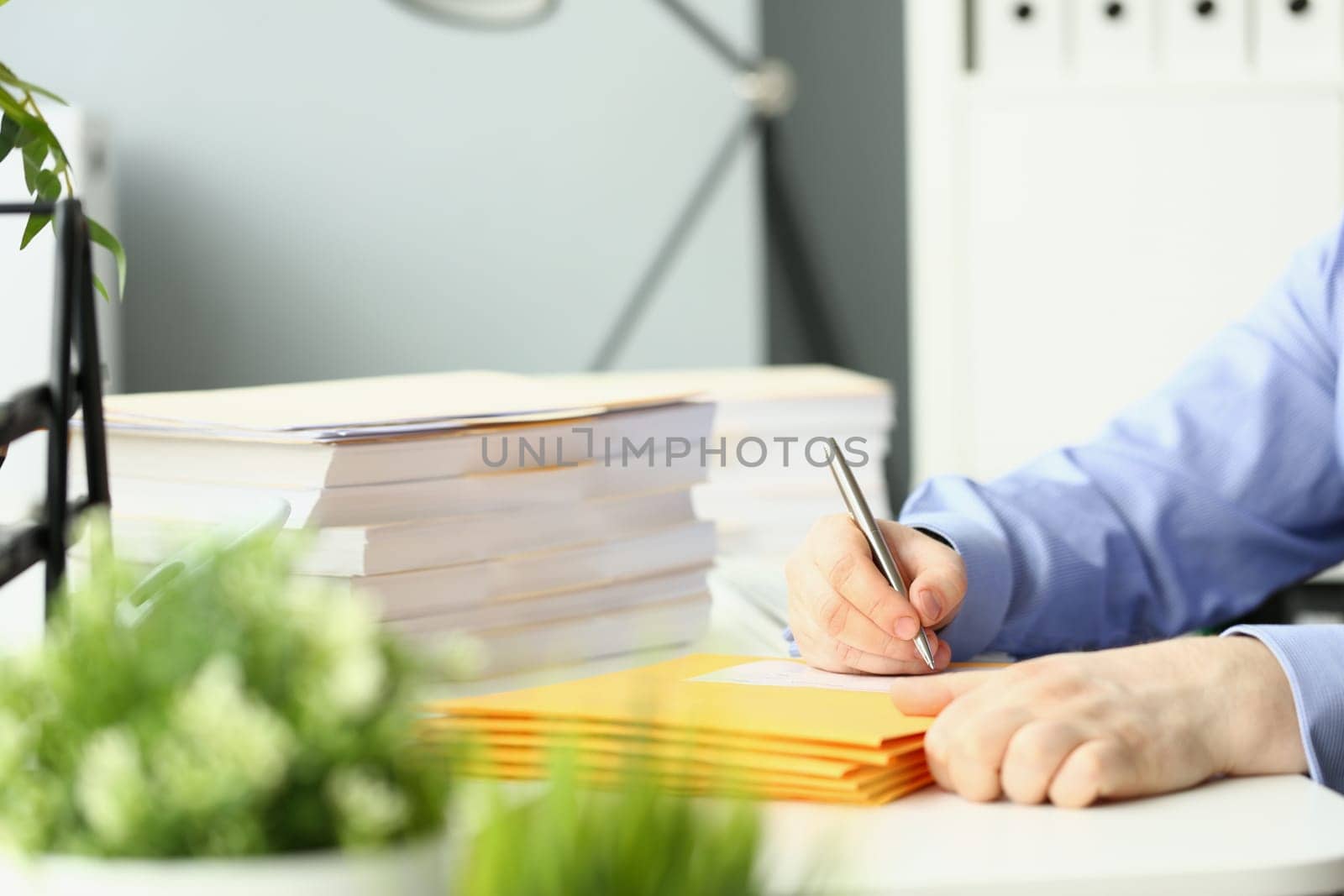 Clerk fills yellow envelopes with mail in office by kuprevich