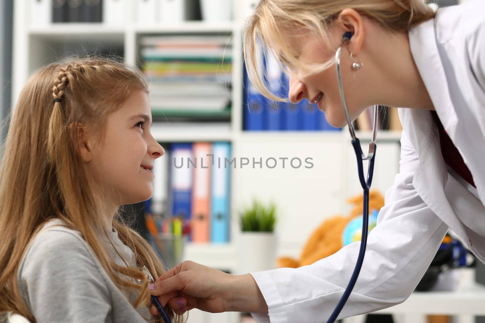 Pediatrician examining small child with stethoscope. Pediatrics and medicine healthcare concept