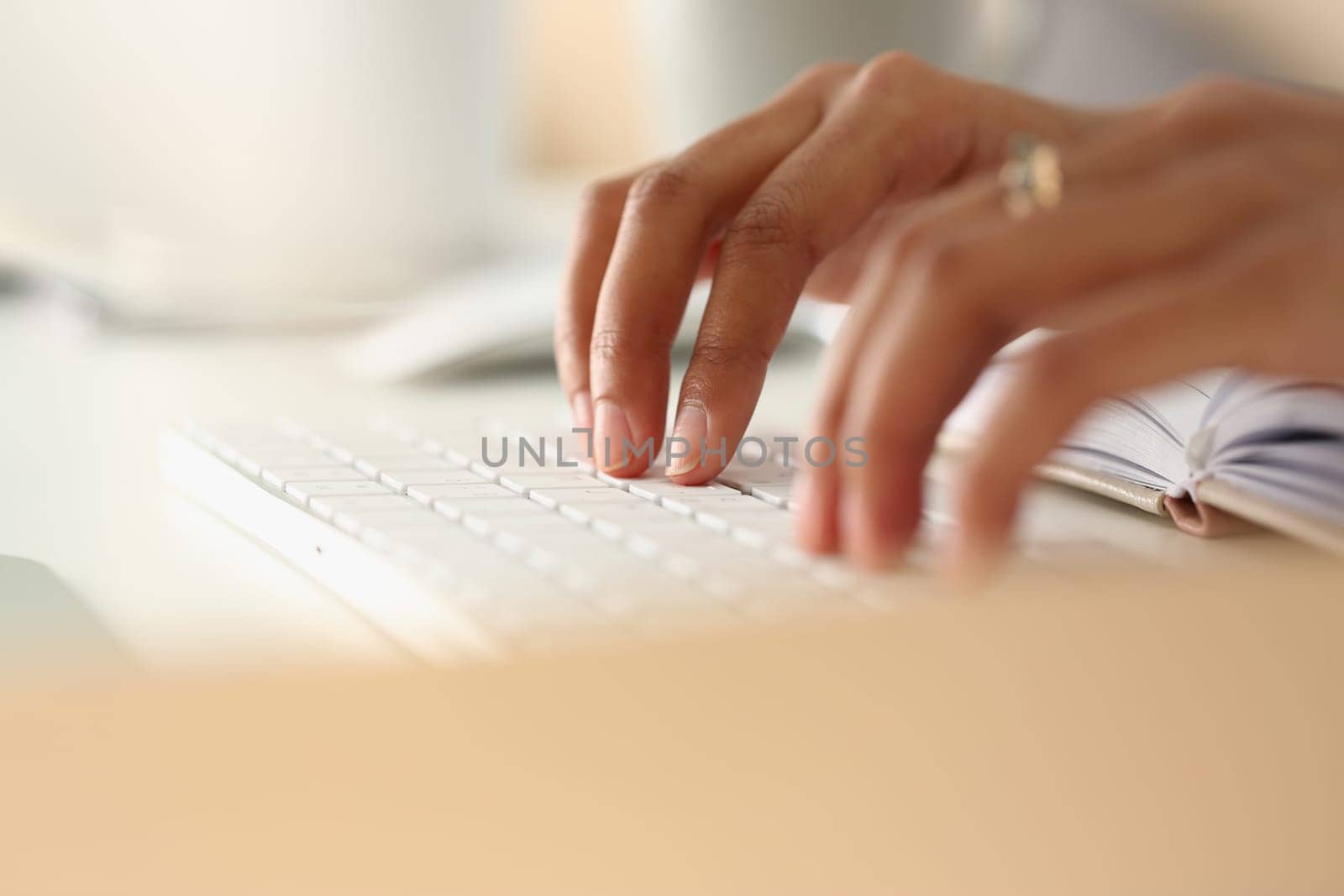 Closeup of African female hands typing on keyboard by kuprevich
