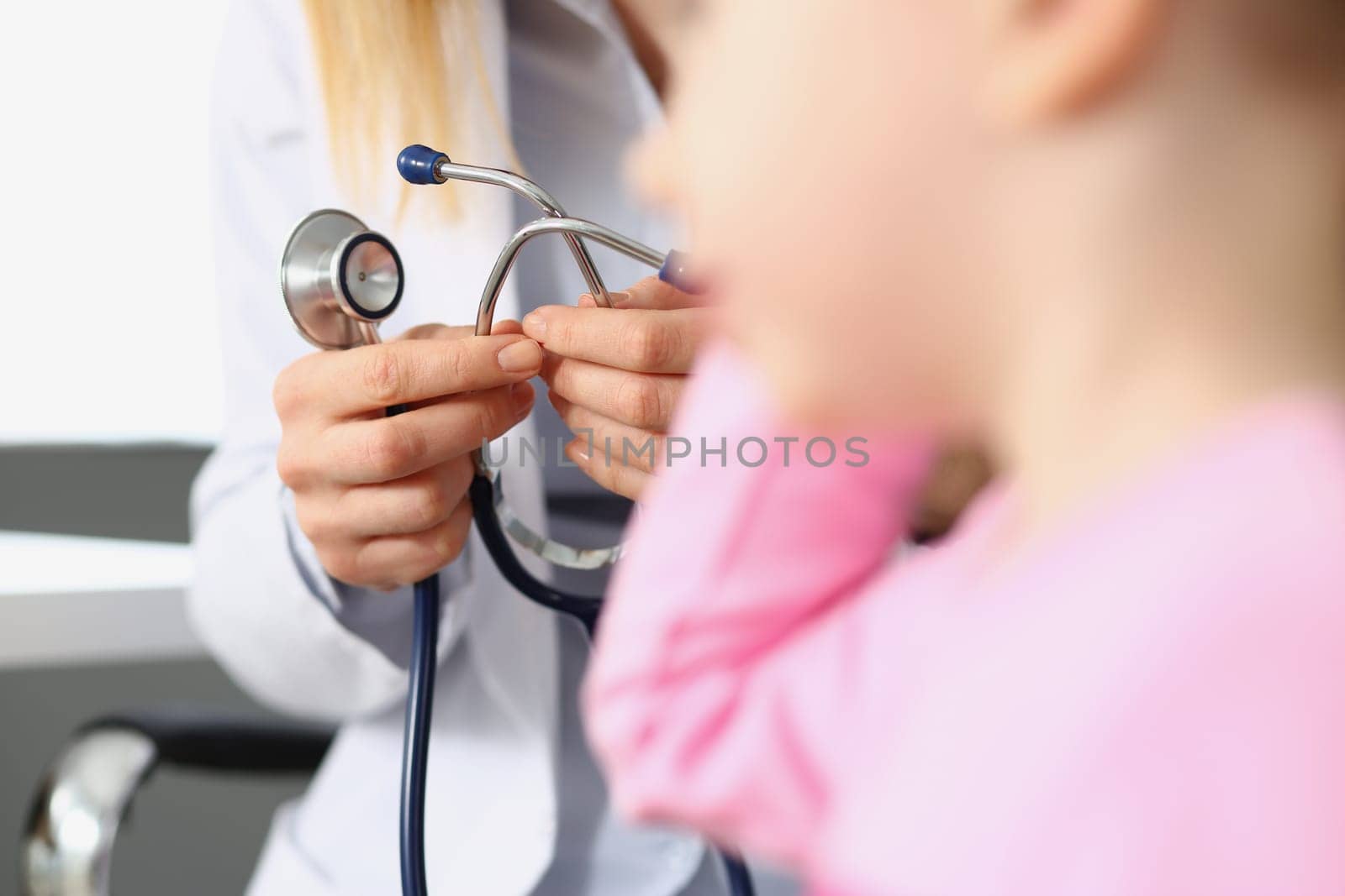 Doctor holds stethoscope at child health consultation. Pediatrician services concept