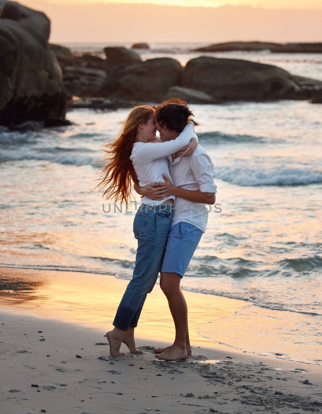 Couple hug on beach, freedom and travel, love and commitment in relationship, adventure and vacation. Trust, partnership and care with people outdoor, romance and happiness at sunset with sea waves.