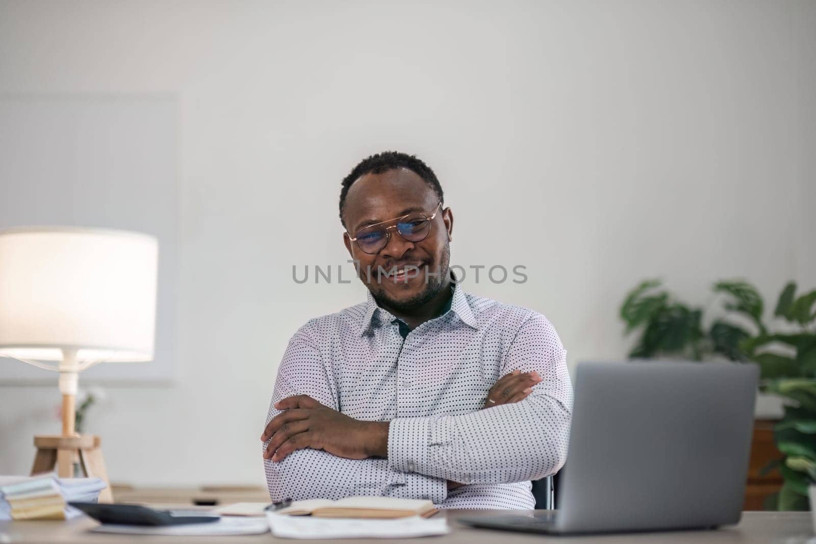 Handsome cheerful african american executive business man at the workspace office.