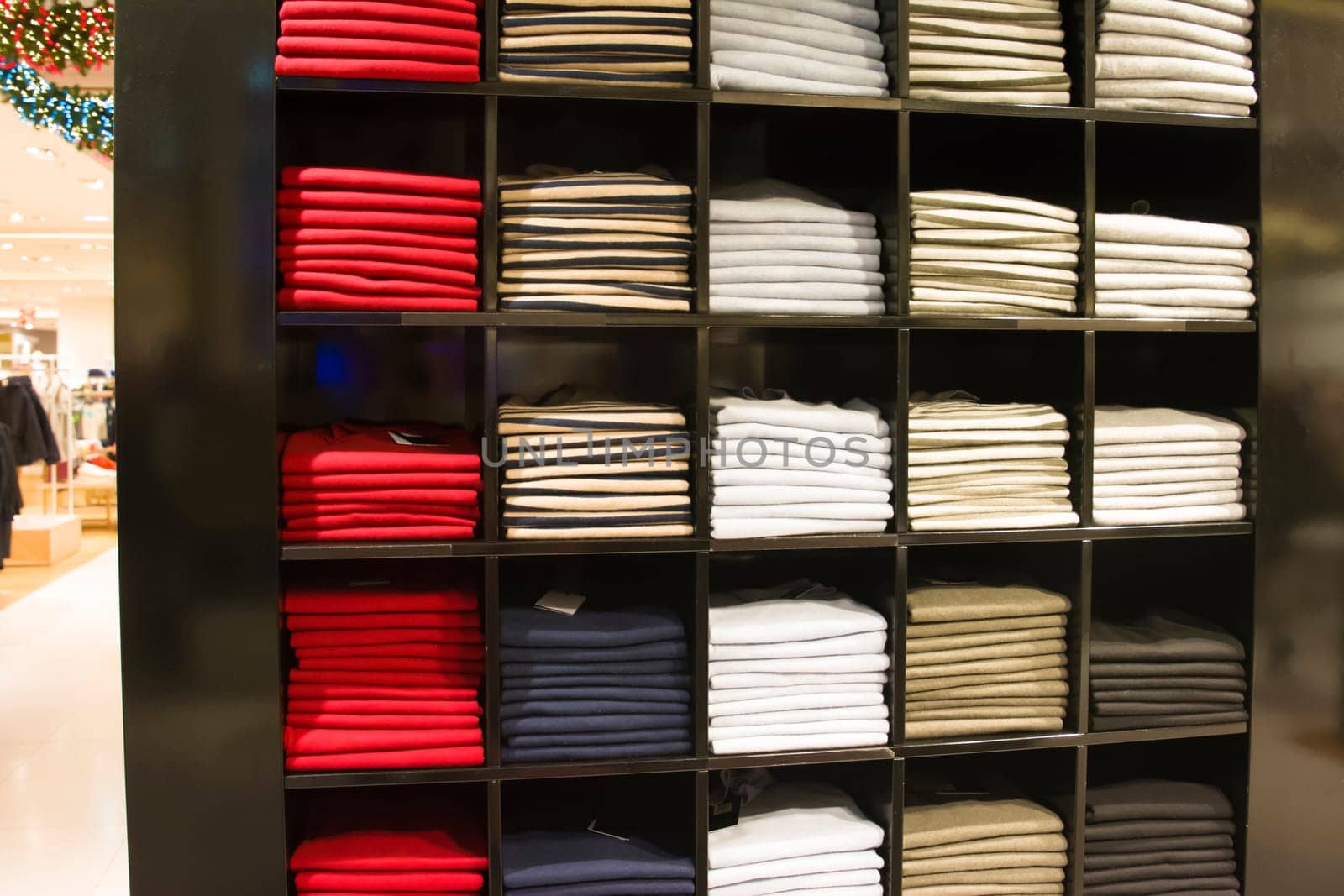 A row of folded jackets on a shelf in the store