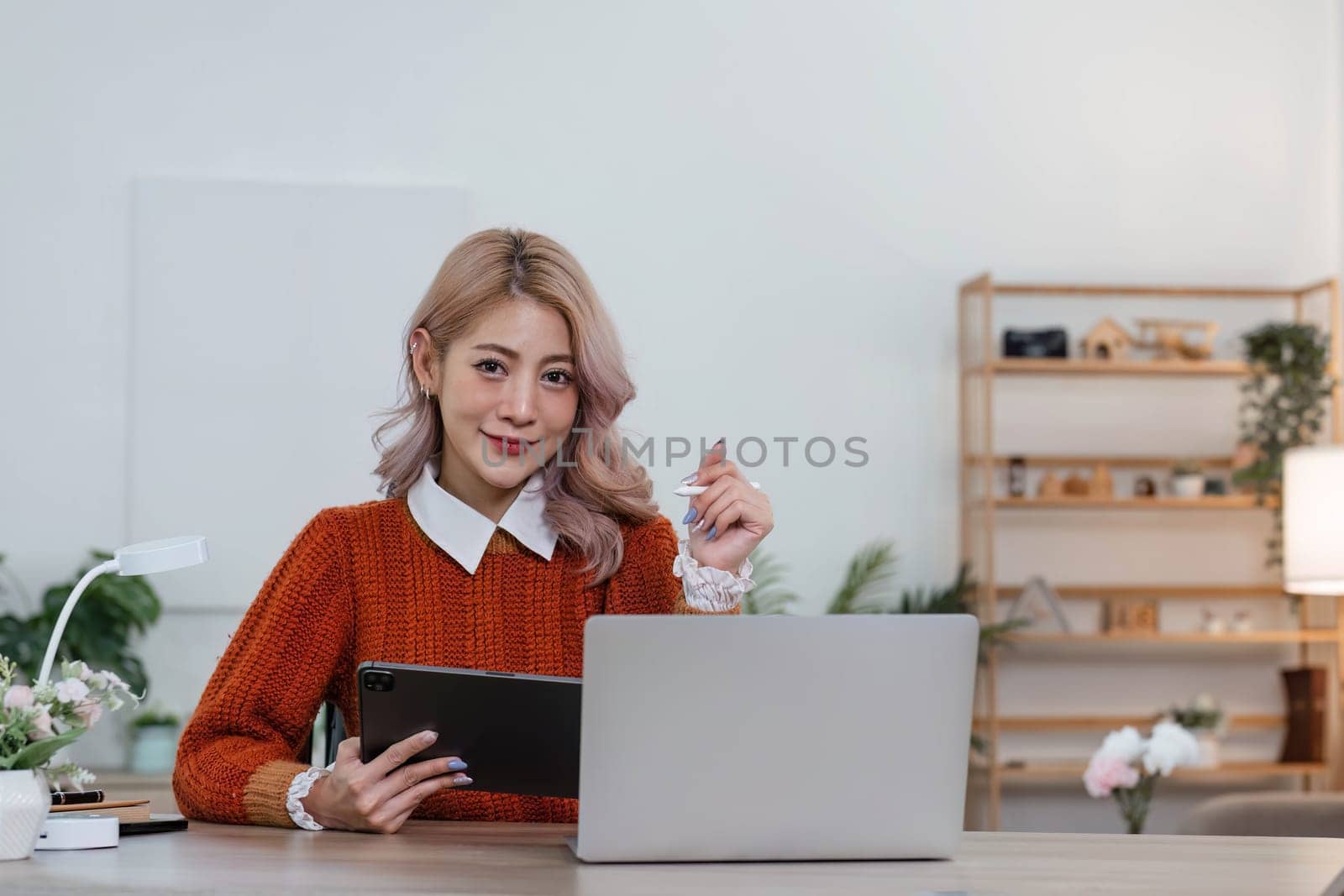 Young asian woman using tablet with smiling face, positive emotion, at home, casual home life concept..