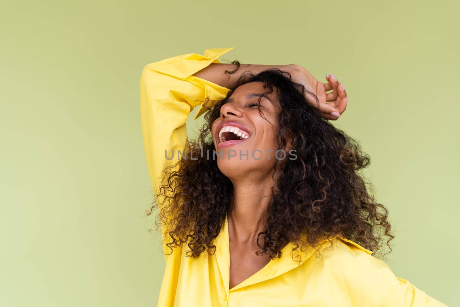 Beautiful african american woman in casual shirt on green background positive smiling laughing enjoying execited by kroshka_nastya