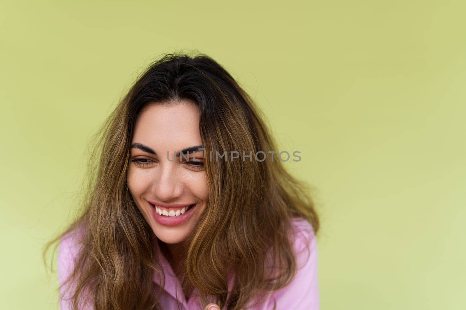 Young woman in casual wear isolated on green background naturally laughing giggling