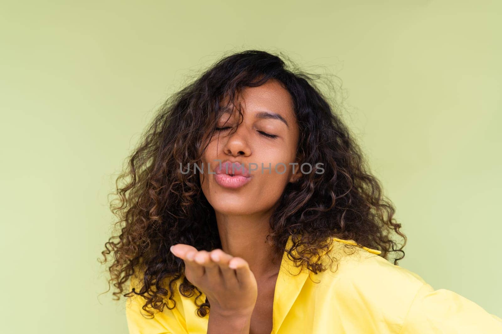 Beautiful african american woman in casual shirt on green background positive smiling laughing enjoying execited