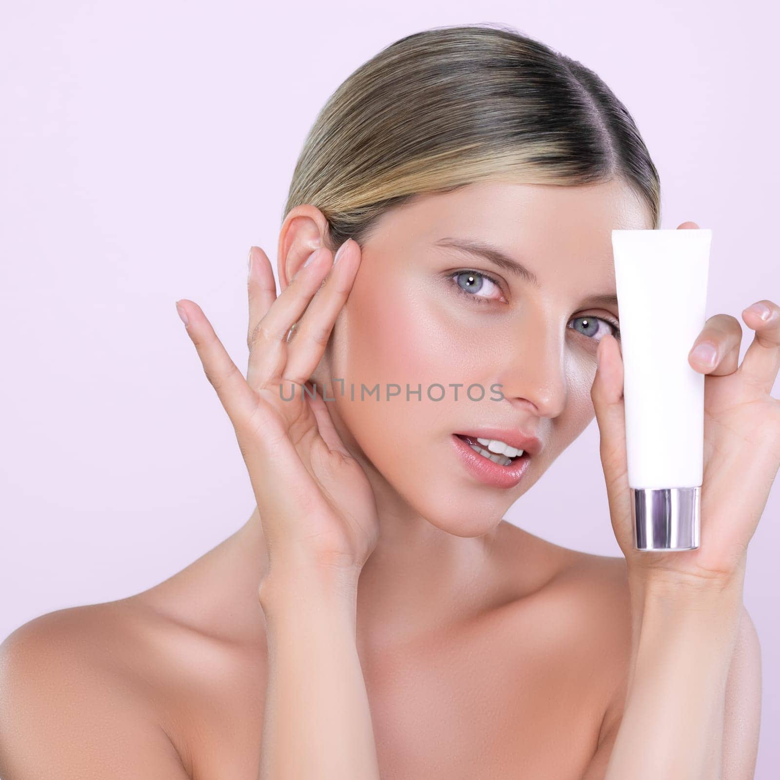 Alluring portrait of perfect skin woman holding mockup moisturizer tube. by biancoblue