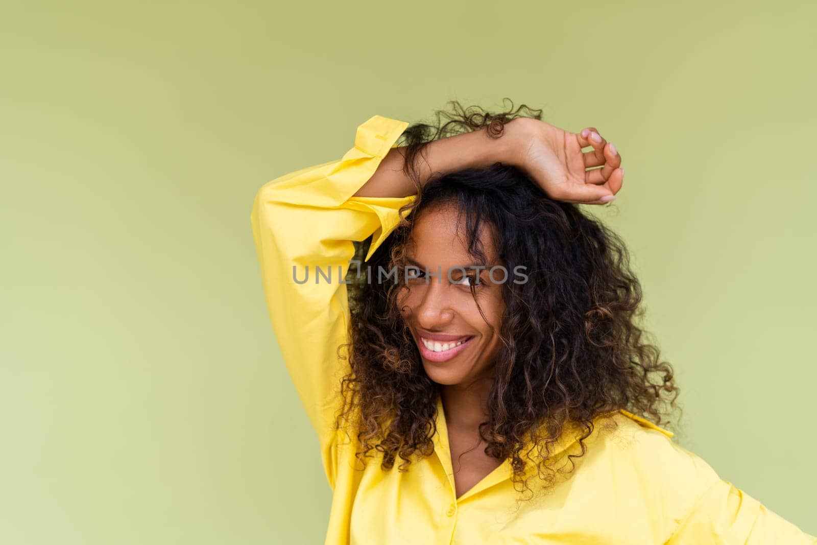 Beautiful african american woman in casual shirt on green background positive smiling laughing enjoying execited by kroshka_nastya