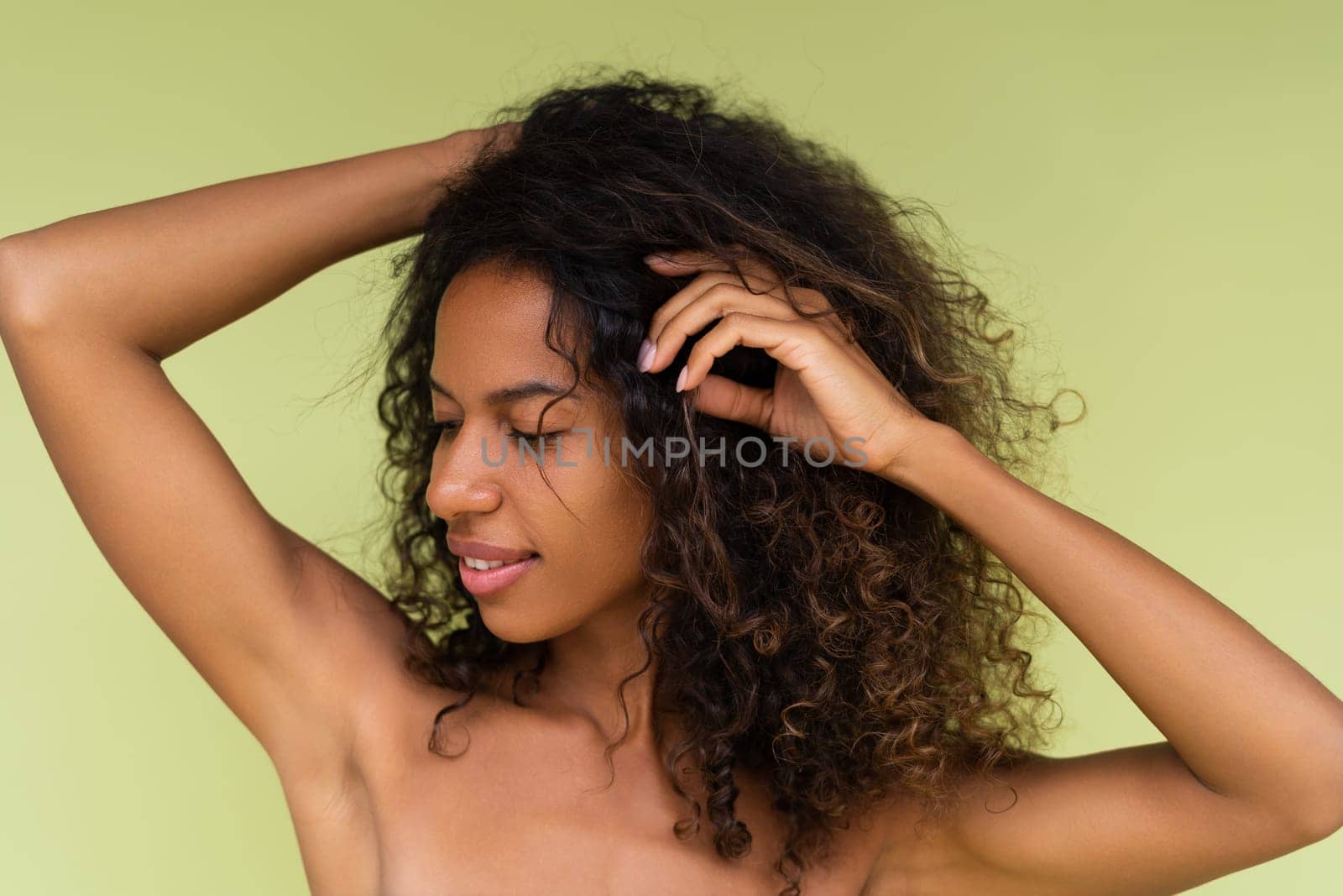 Beauty portrait of young topless african american woman with bare shoulders on green background with perfect skin and natural makeup by kroshka_nastya