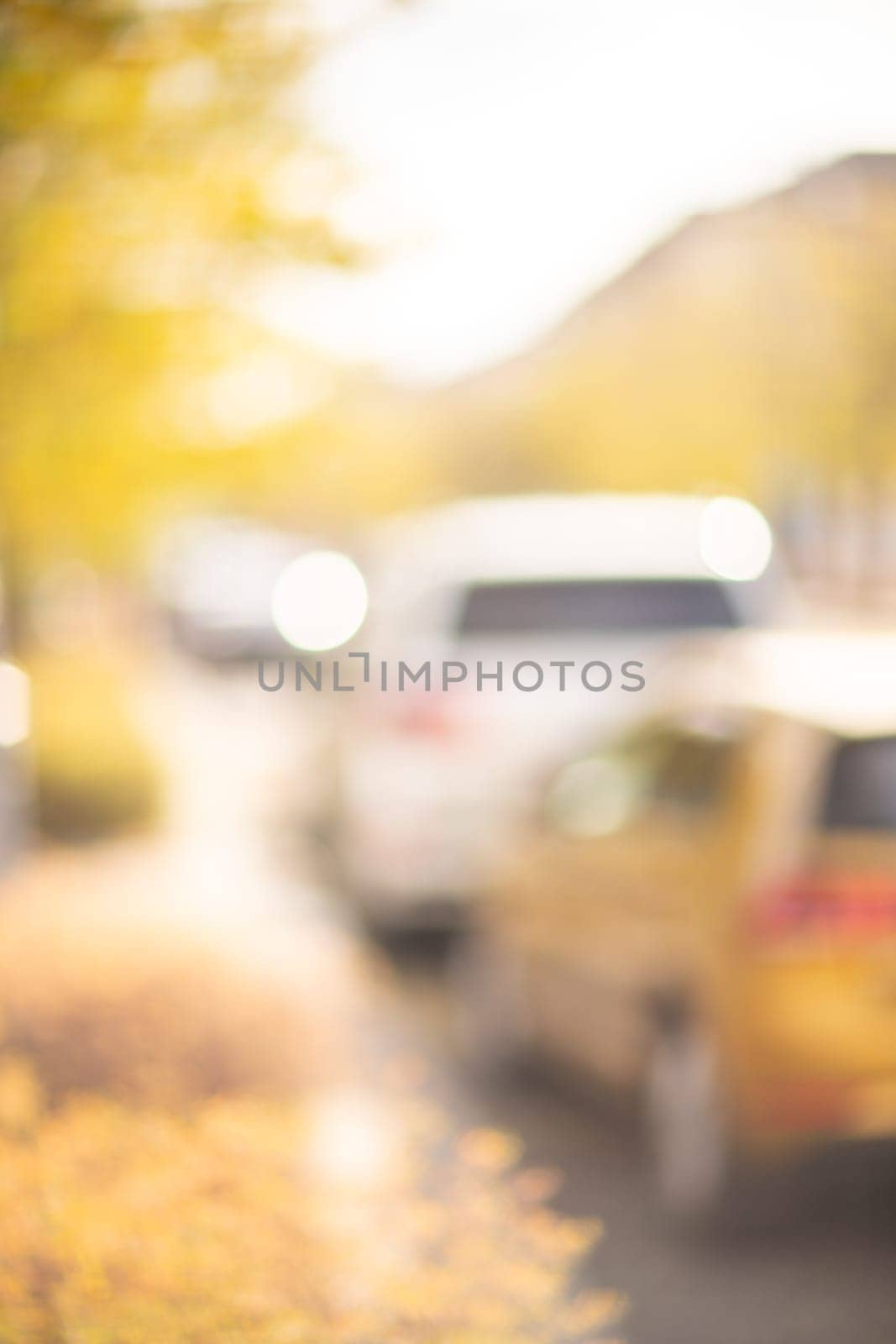Autumn season bokeh background. Abstract city blur along the road with cars. by Matiunina