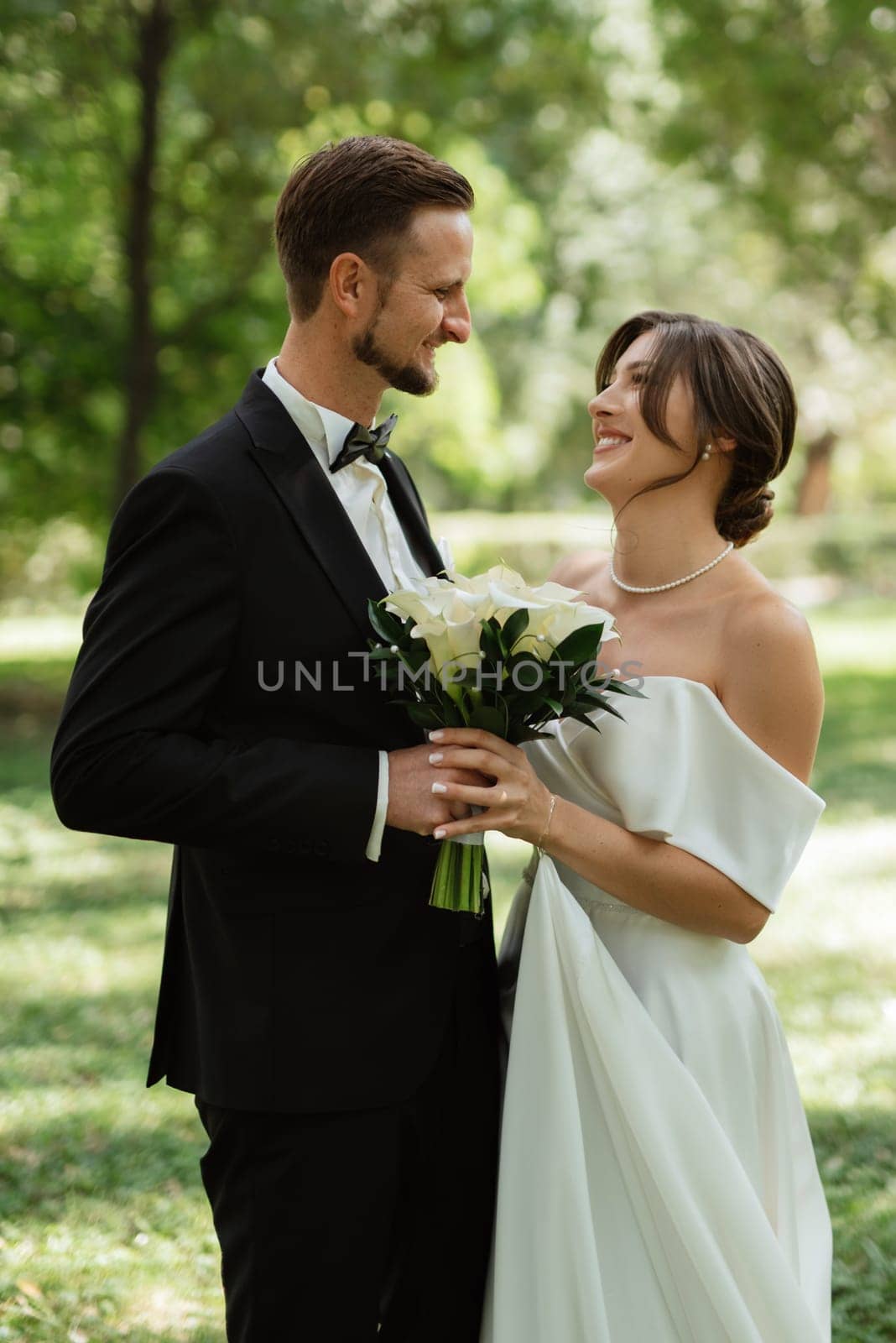 the first meeting of the bride and groom in wedding outfits in the park