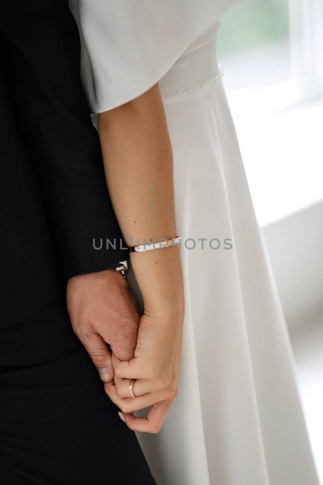 groom in a black suit tie and the bride in a bright studio by Andreua