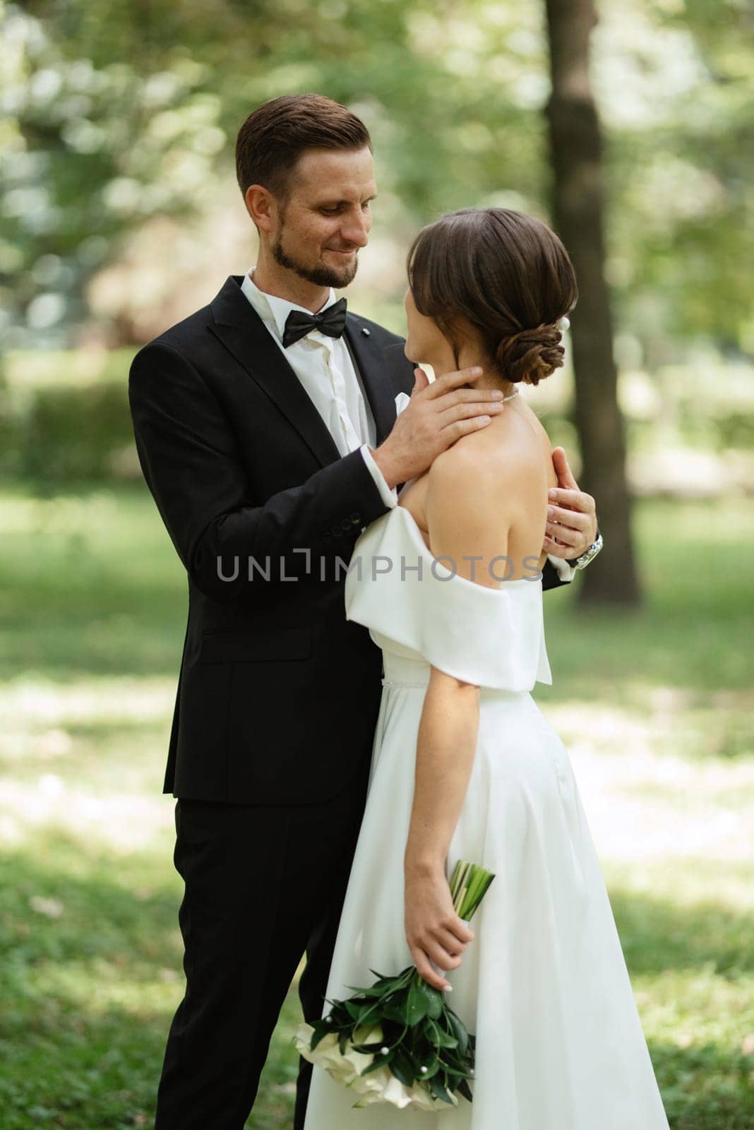 the first meeting of the bride and groom in wedding outfits in the park