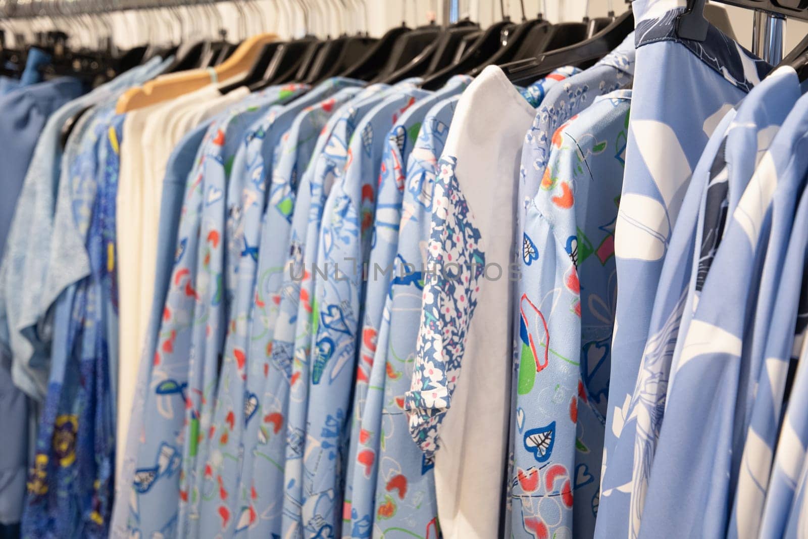 blue and white summer blouses on a hanger in the store, bright summer clothes, High quality photo