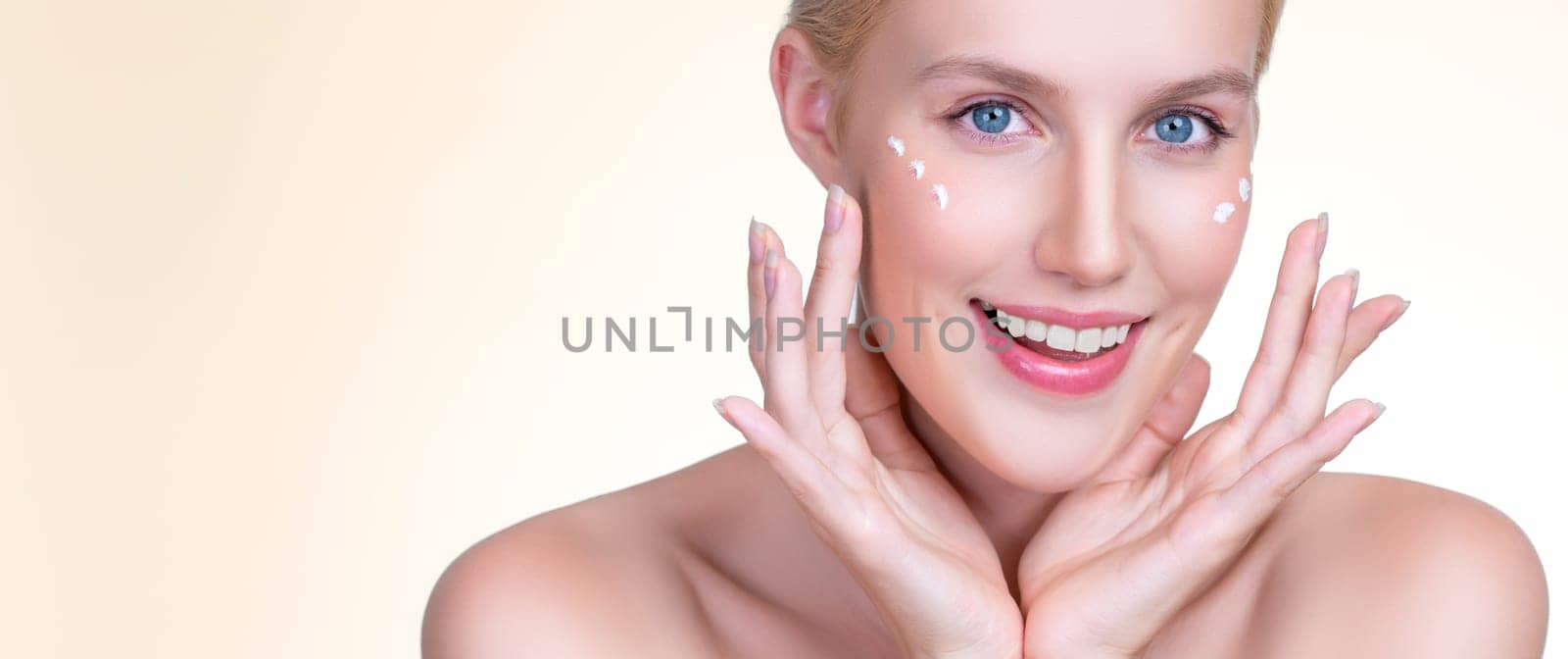 Personable beautiful perfect clean skin soft makeup woman finger applying moisturizer cream on her face under contour eye for anti aging wrinkle. Facial skin rejuvenation in isolated background.