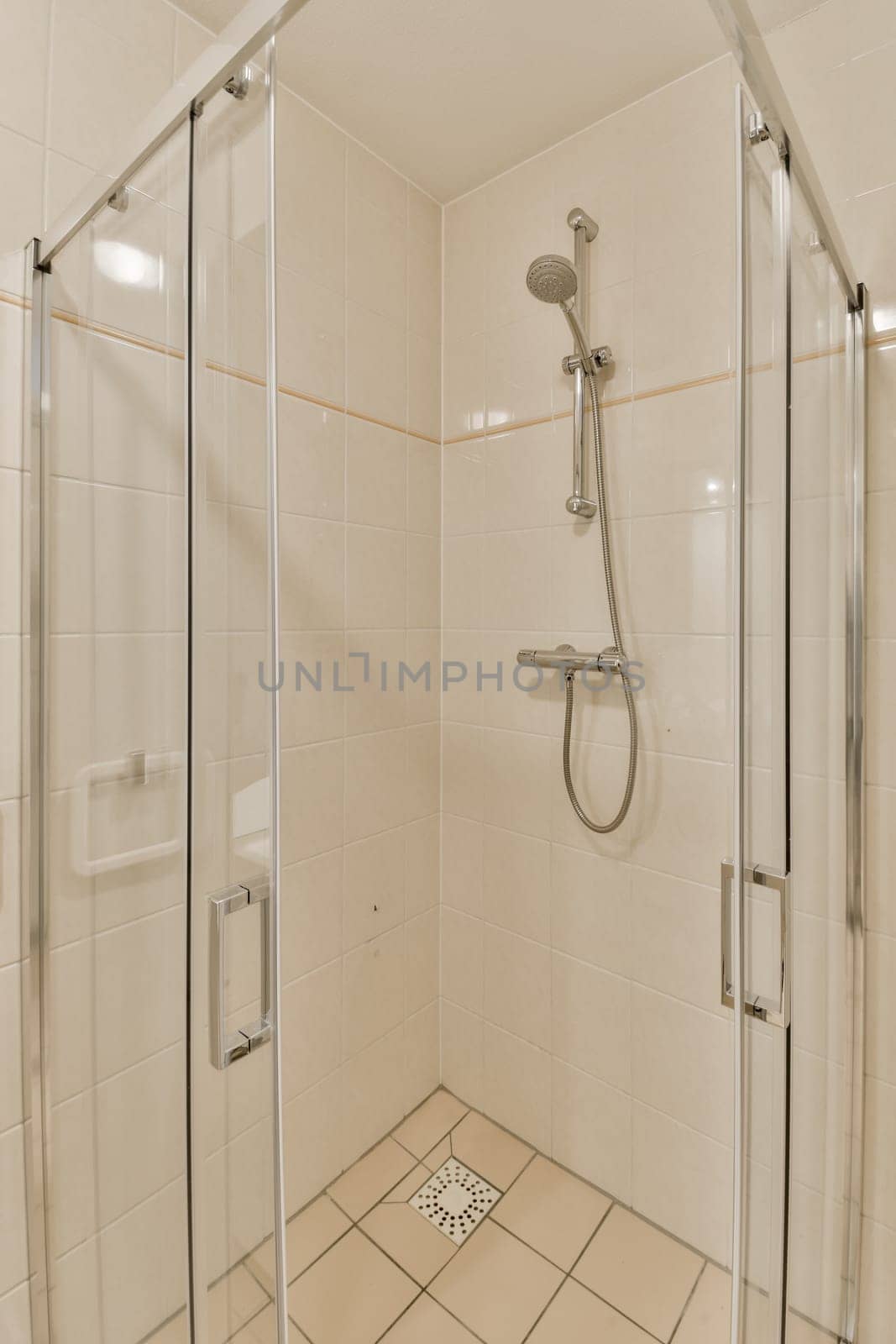 a shower with a glass door in a bathroom by casamedia