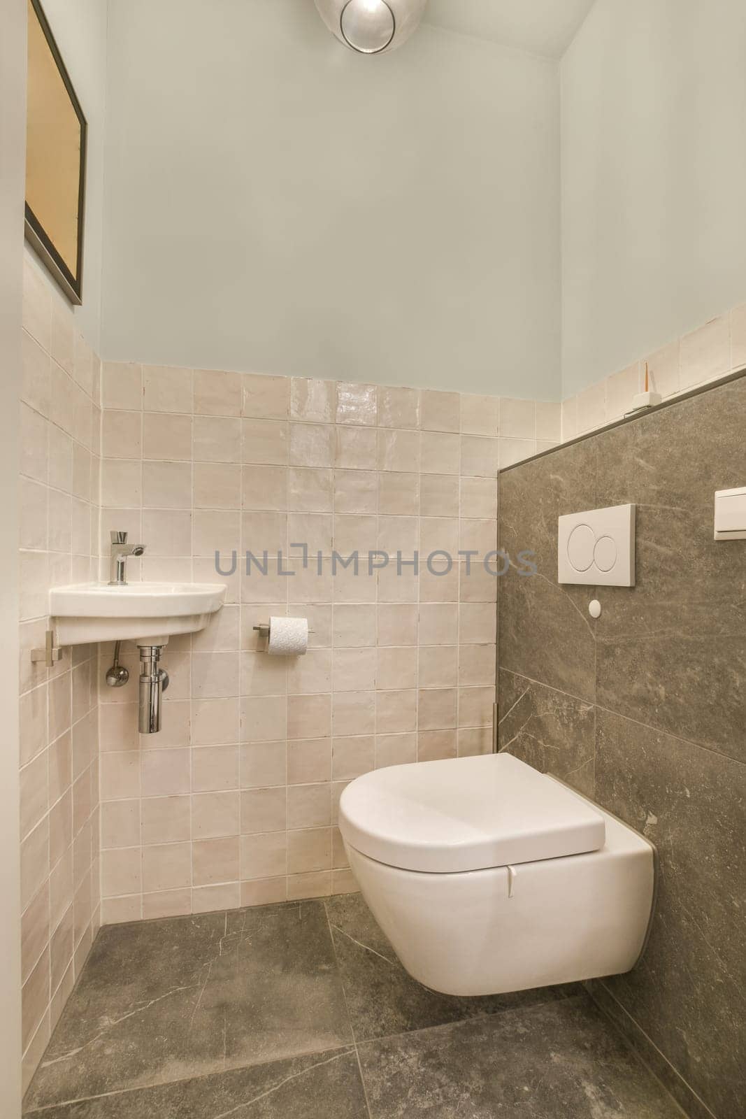 a small bathroom with a toilet and sink in the corner, all made up of white marble tiles on the walls