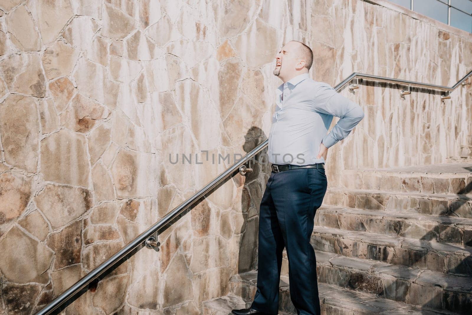Portrait of a senior professional man in a suit with various problems. A middle-aged businessman with a briefcase descends the stairs.