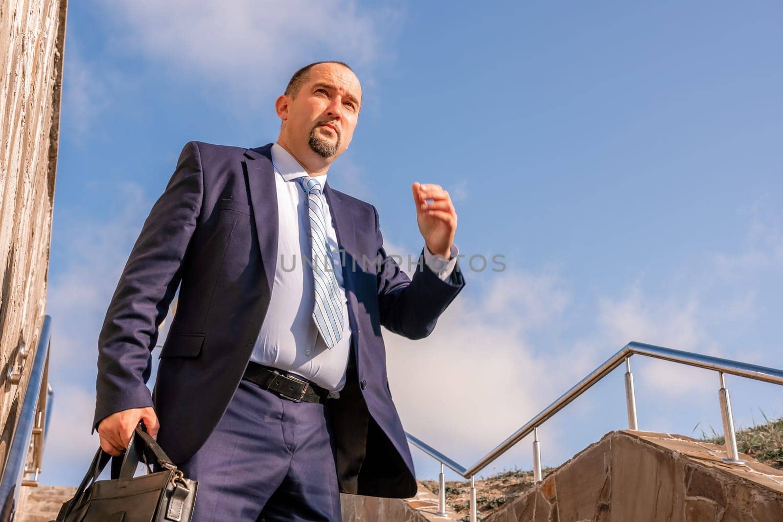 Business executive with briefcase going down the stairs.