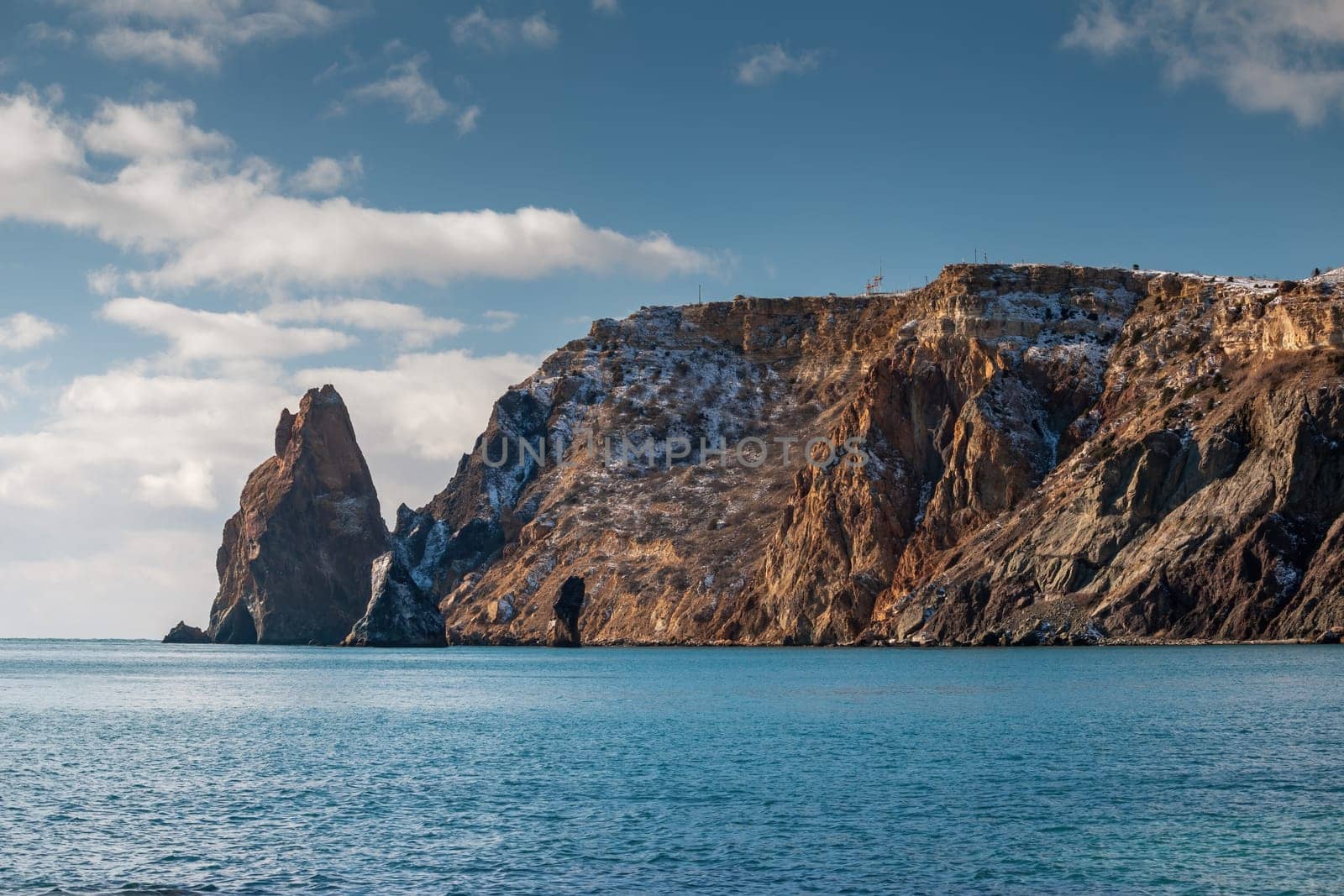 calm azure sea and volcanic rocky shores. Small waves on water surface in motion blur. Nature summer ocean sea beach background. Nobody. Holiday, vacation and travel concept by panophotograph