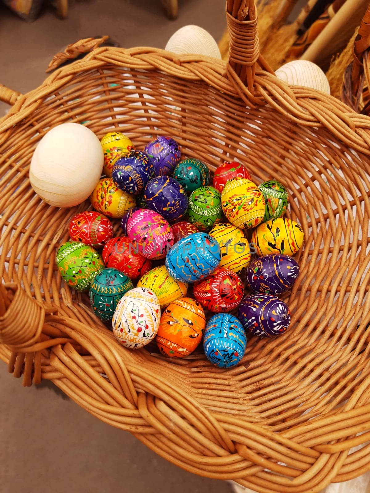 On the eve of Easter, holiday decorations in the form of colorful Easter eggs in a basket close-up.