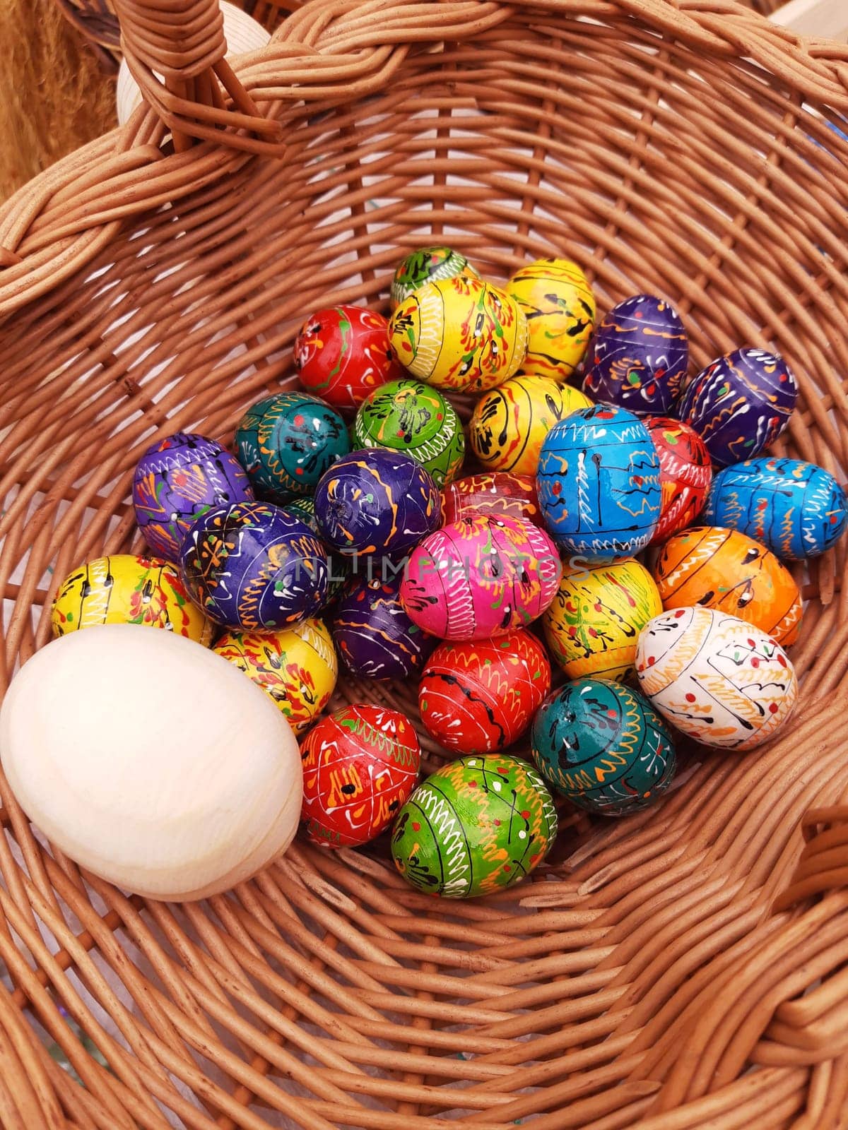 On the eve of Easter, holiday decorations in the form of colorful Easter eggs in a basket close-up.