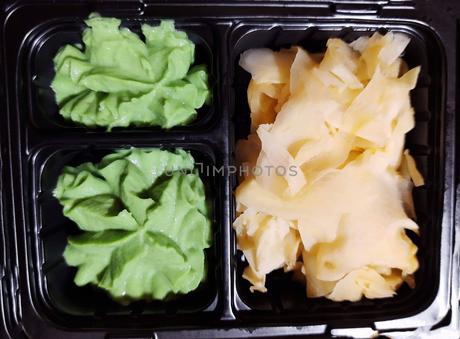 Ginger and wasabi for sushi in a container close-up.