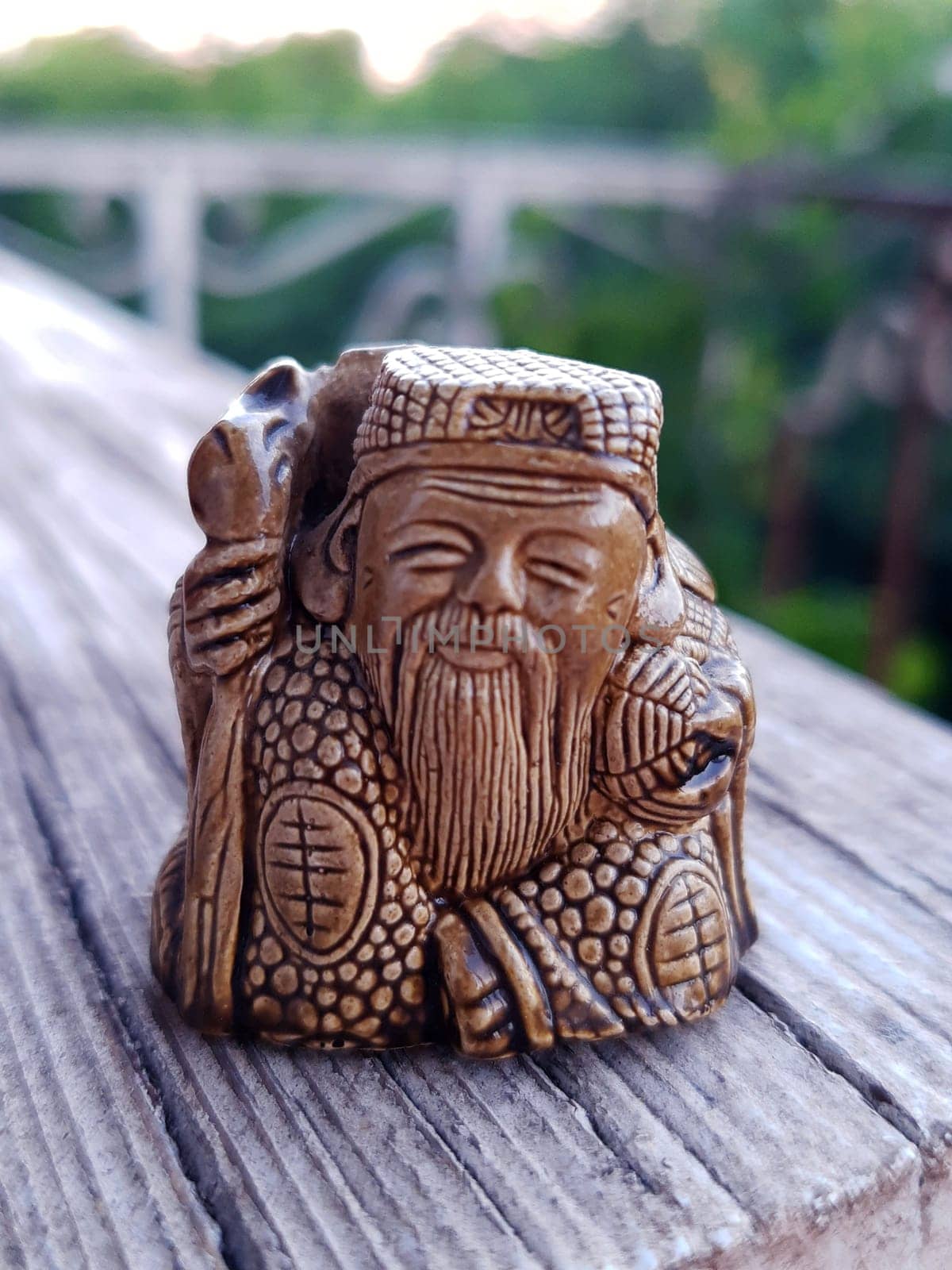 Netsuke Zaoshen made of ceramics on a gray background close-up.