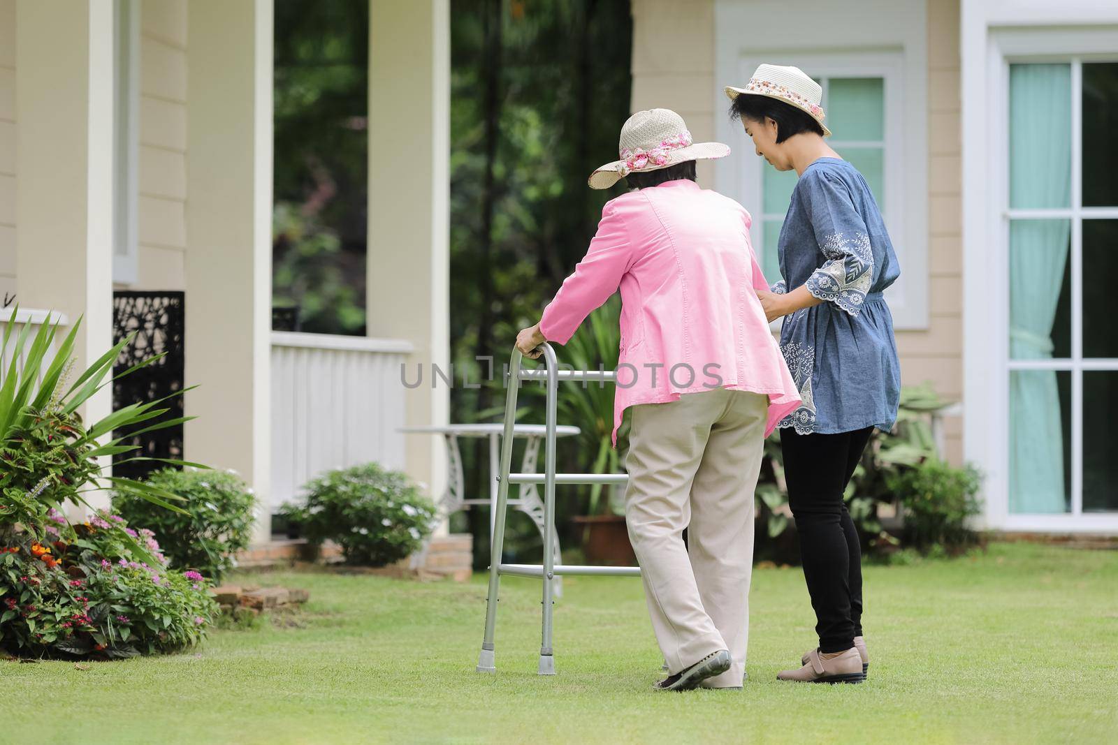 Elderly woman exercise walking in backyard with daughter by toa55
