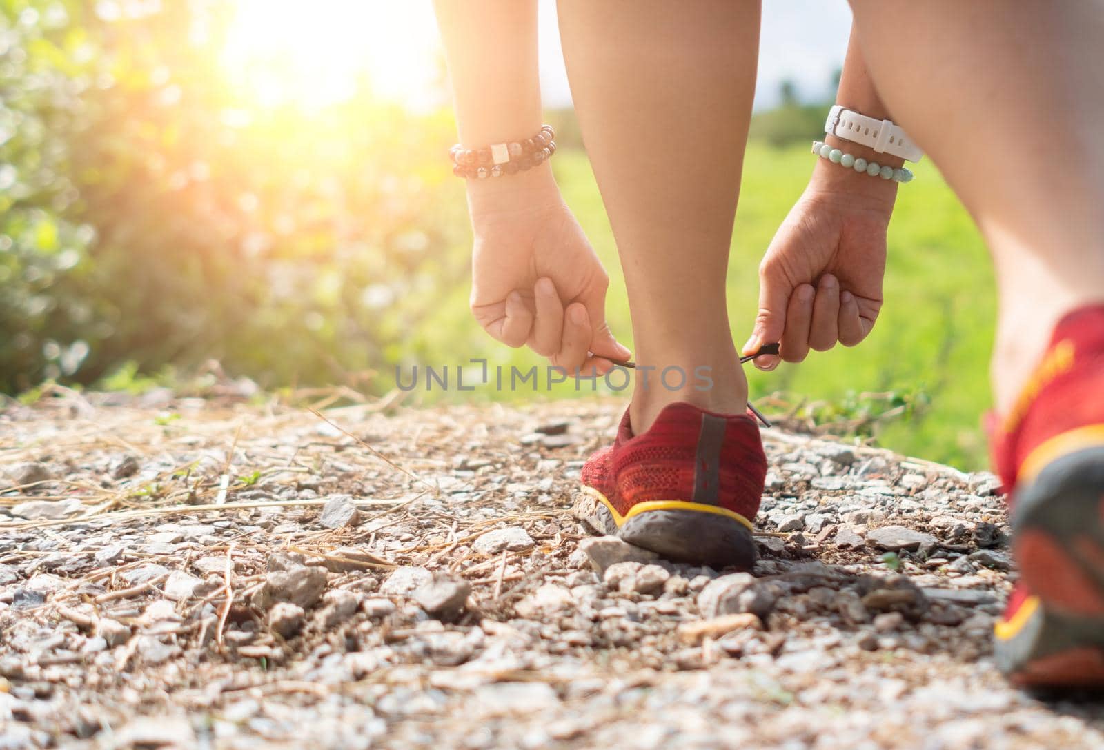 Woman wear running shoe on to walking and running on nature green background.Health exercise. by Suwant