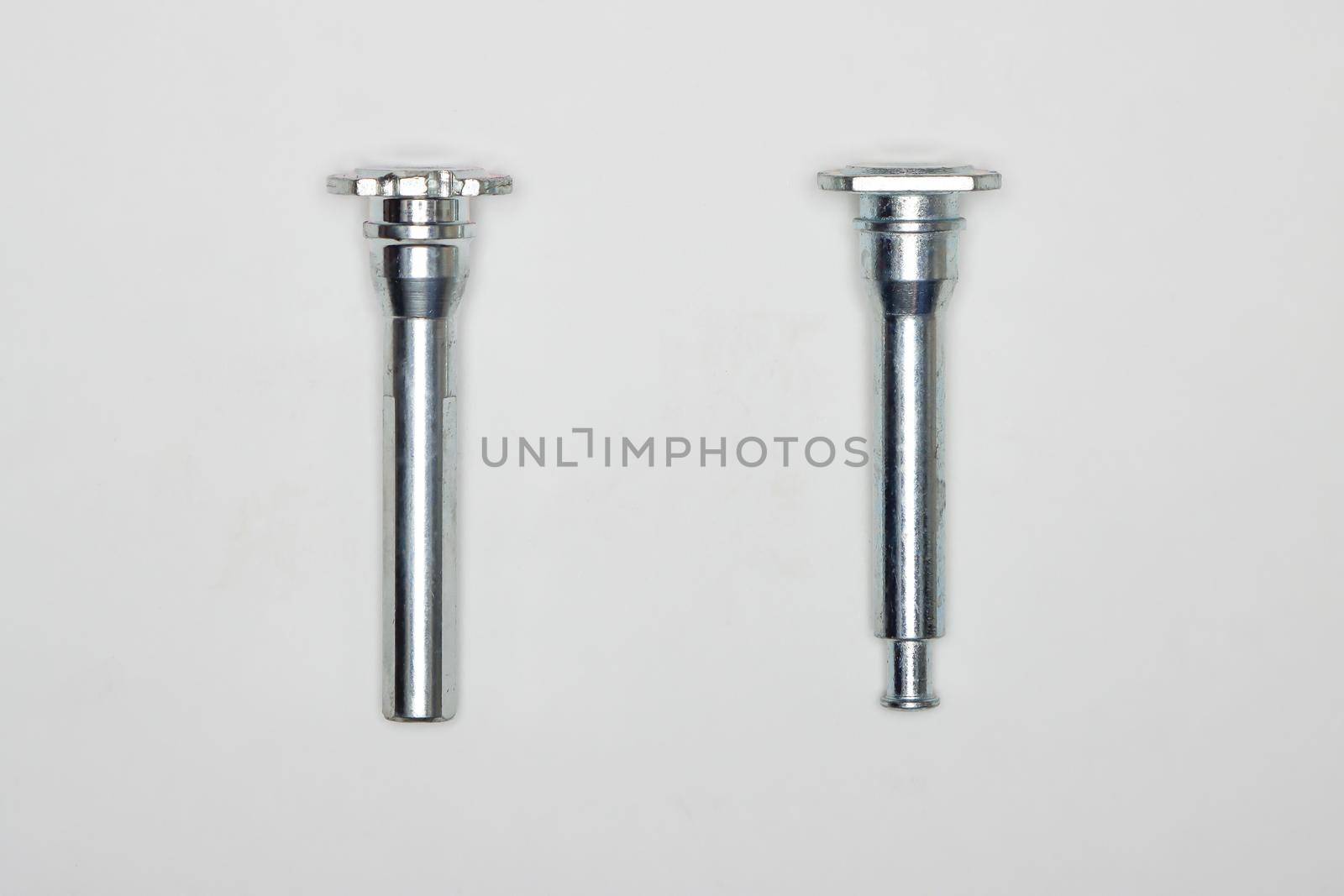 Two metal fingers, machine repair parts. A set of spare parts for servicing the braking system of a vehicle. Details on white background, copy space available.