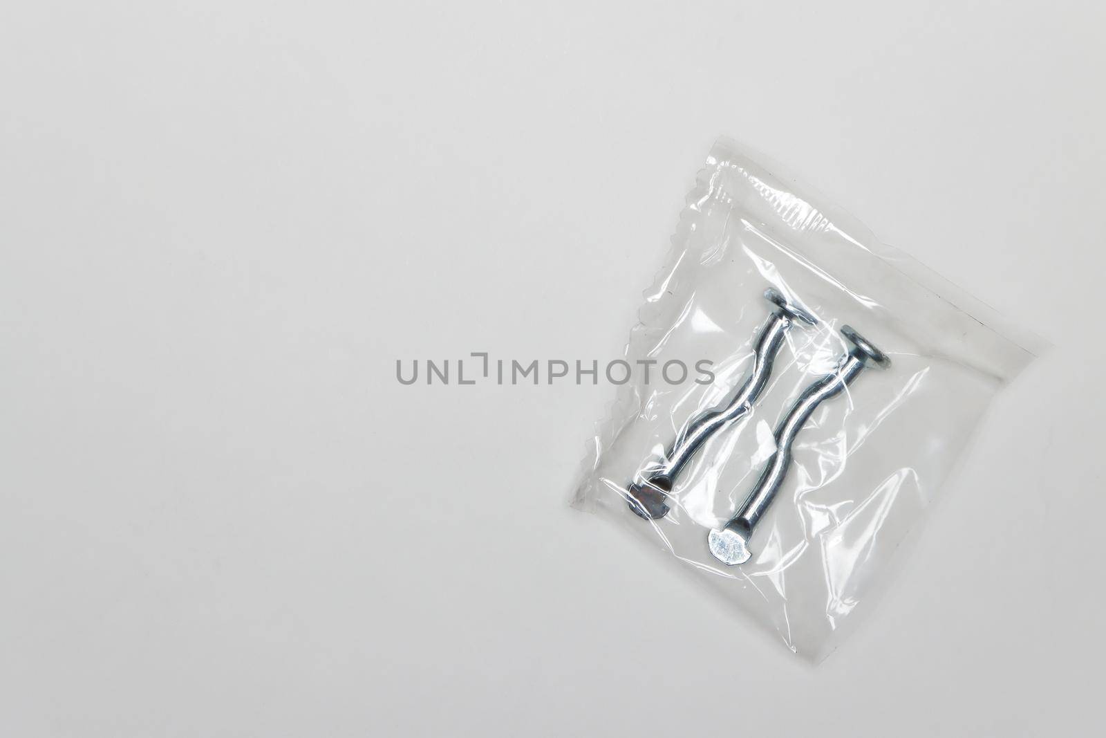 Two metal curved fingers per package, machine repair parts. A set of spare parts for servicing vehicle calipers. Details on white background, copy space available.