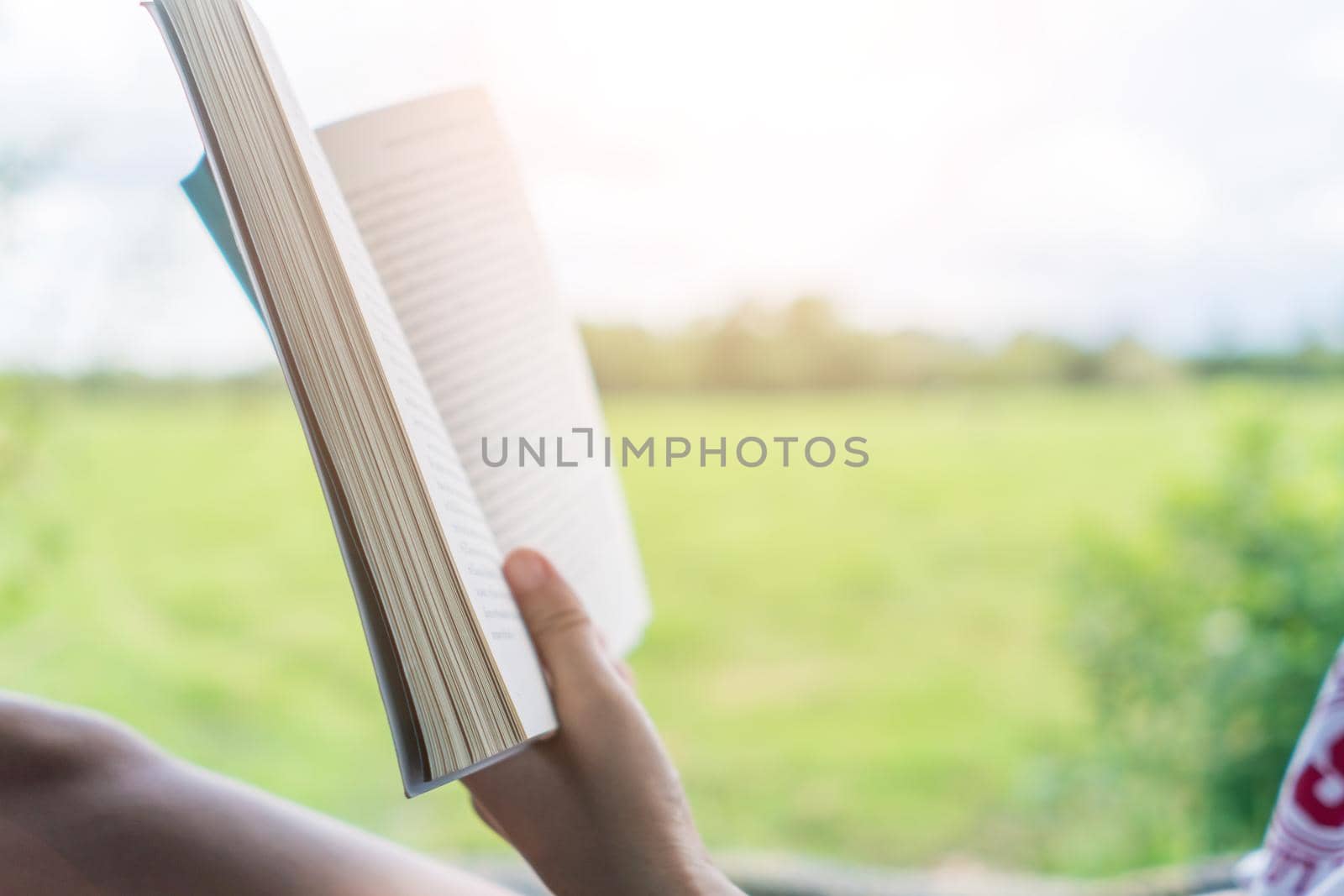 Woman is reading book in beautiful park and pond relax and peaceful environment by Suwant