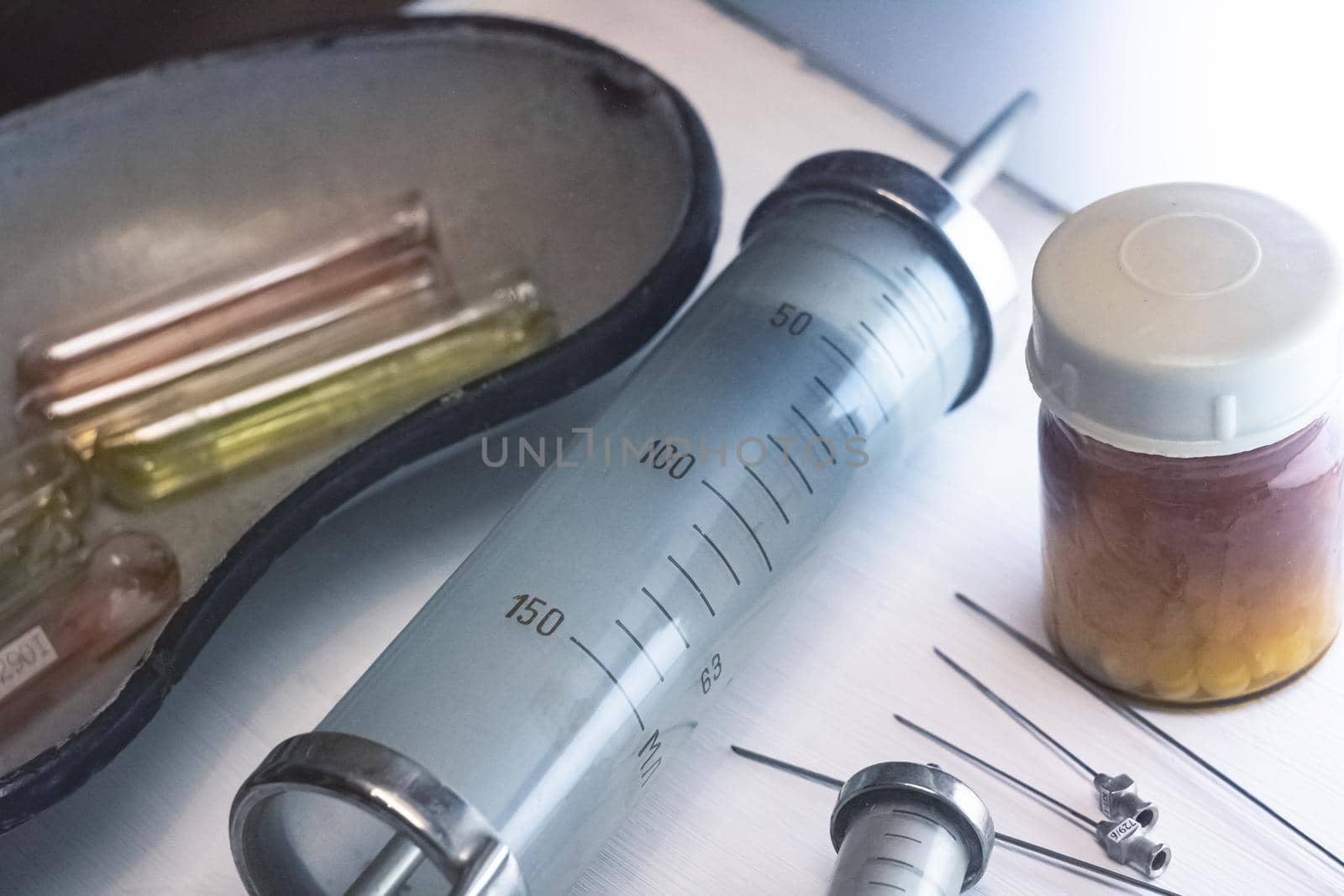 Old reusable syringe, needles and ampoules close up
