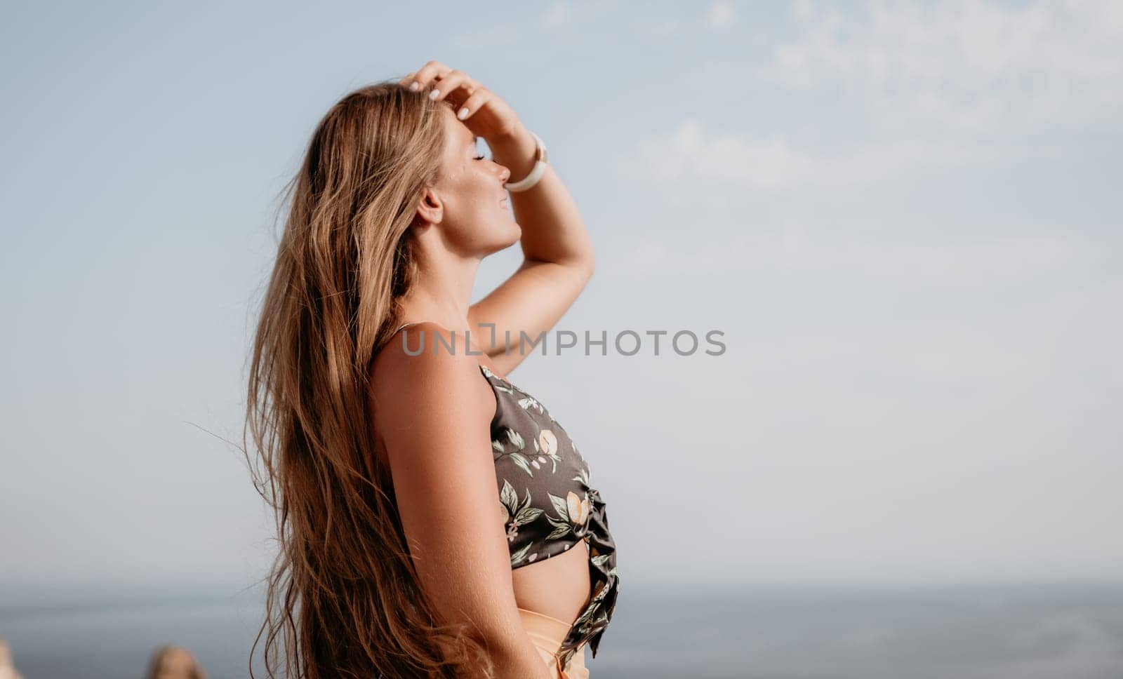 Woman travel sea. Happy tourist taking picture outdoors for memories. Woman traveler looks at the edge of the cliff on the sea bay of mountains, sharing travel adventure journey by panophotograph