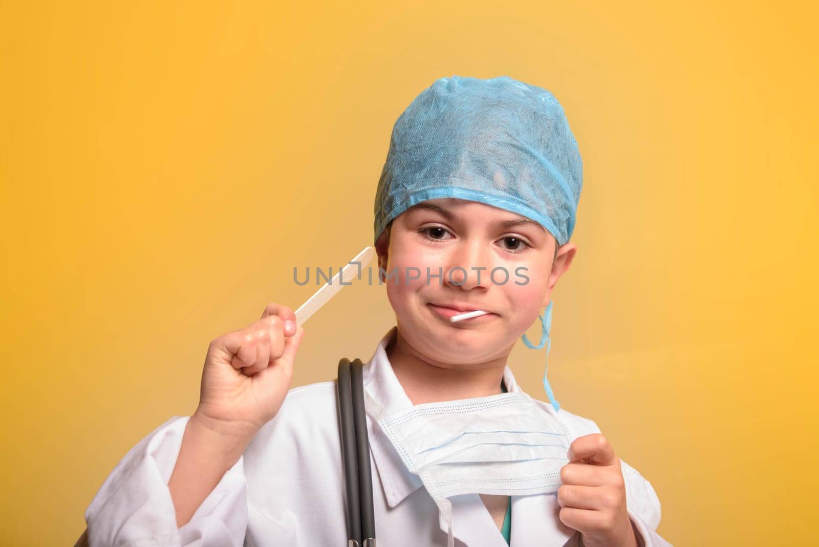 Smiling child boy doctor on yellow background. Male doc in white medical gown. Healthcare health medicine concept. Mock up copy space