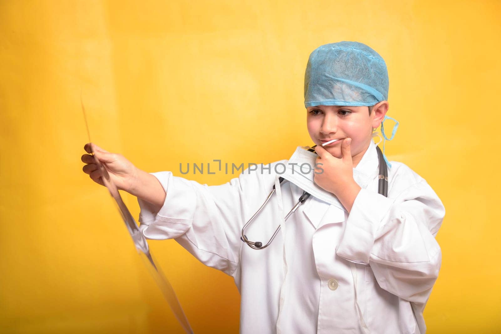 Smiling child boy doctor on yellow background. Male doc in white medical gown. Healthcare health medicine concept. Mock up copy space. by jbruiz78