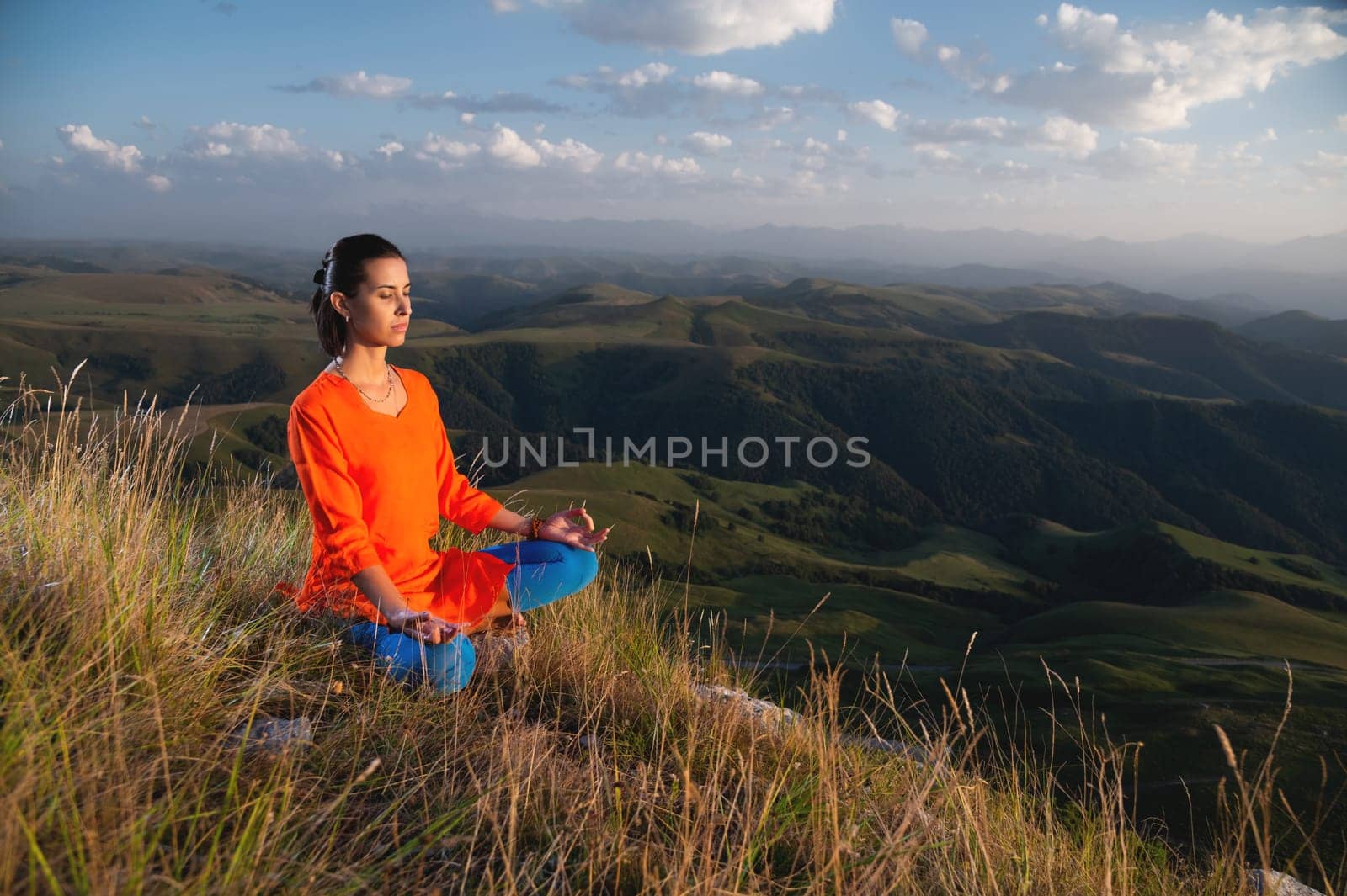 Attractive woman doing yoga. Healthy lifestyle. Woman doing yoga in the mountains. Girl doing yoga at sunrise. Woman meditates in nature. Meditation in the mountains by yanik88