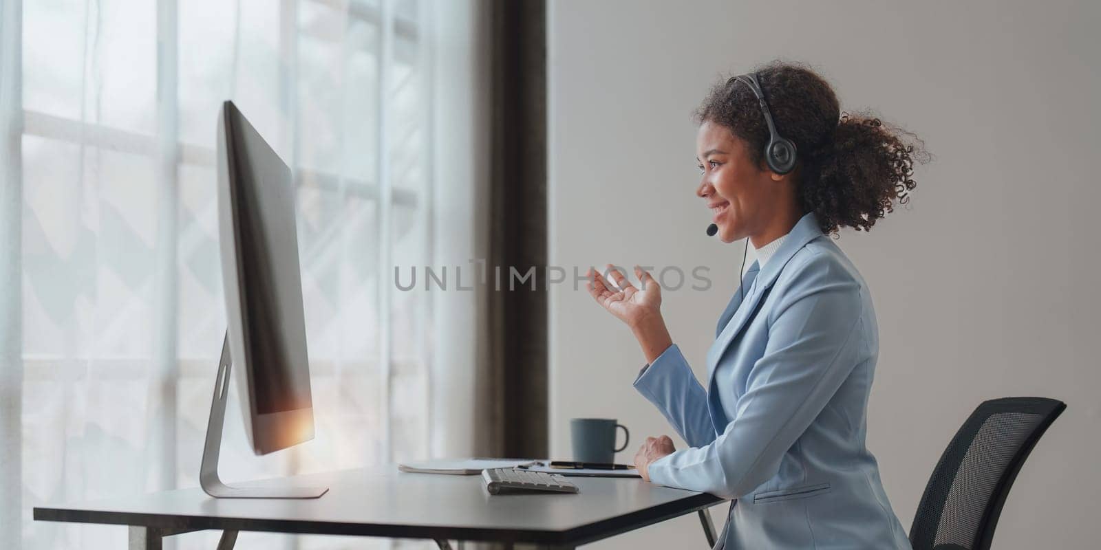 American African friendly operator woman agent with headsets working in a call center. Help desk client online.