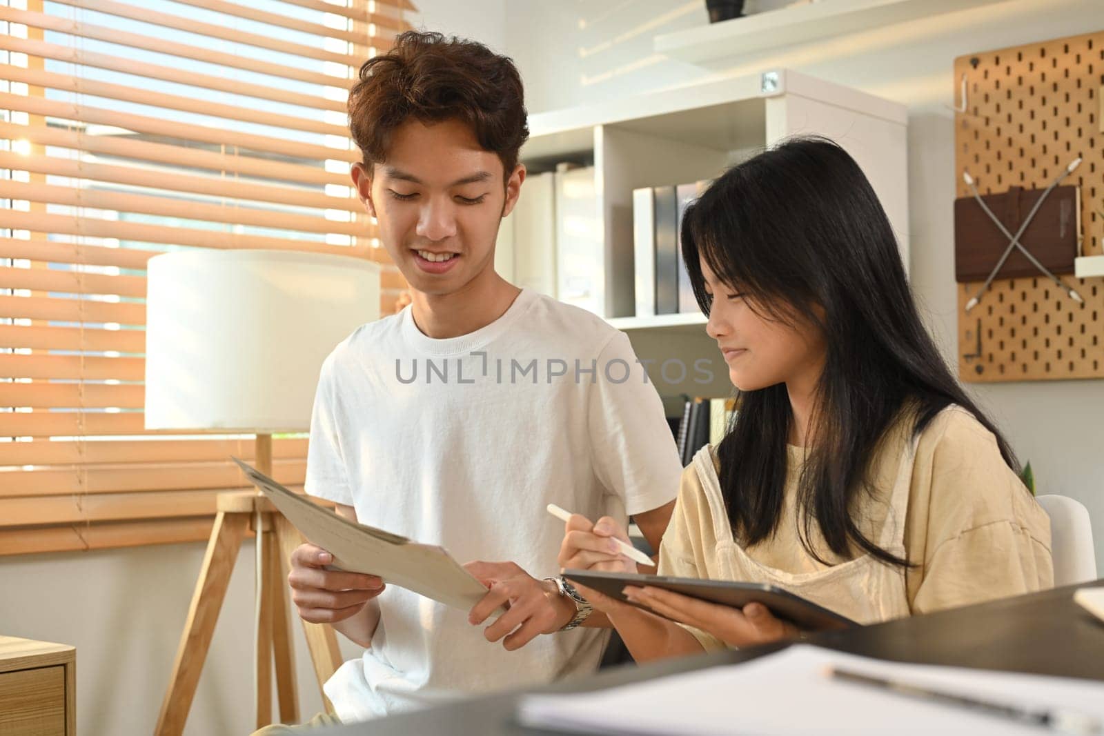 Teenage student woman doing homework and lesson practice preparing exam with tutor. Education and homeschooling concept by prathanchorruangsak