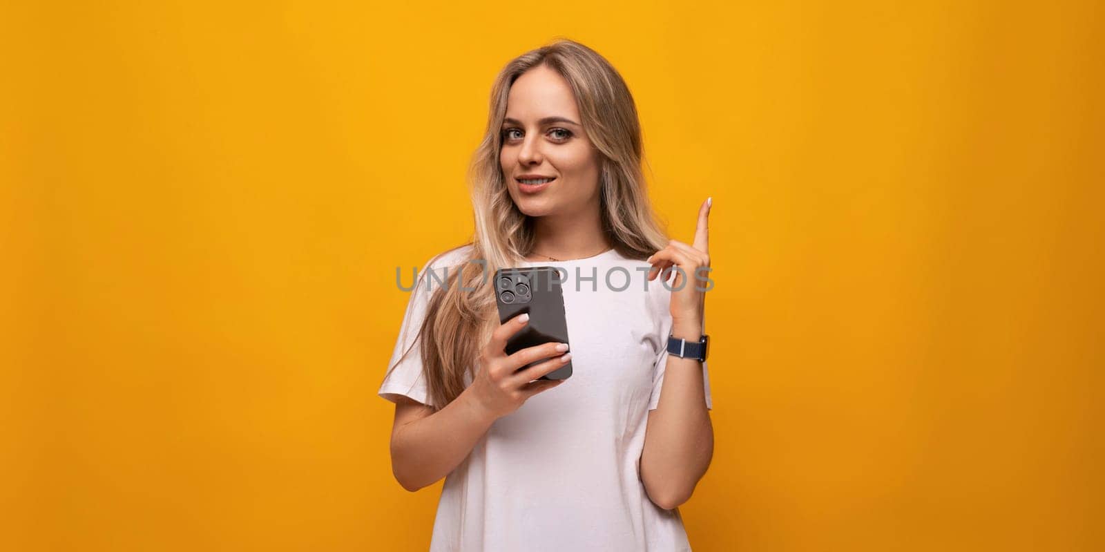 student girl with a phone in her hands on a yellow background by TRMK