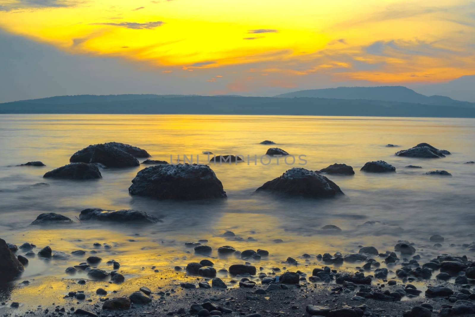 Rocks on the beach during sunrise in Banyuwangi, Indonesia. Long exposure photography. Defocused.
