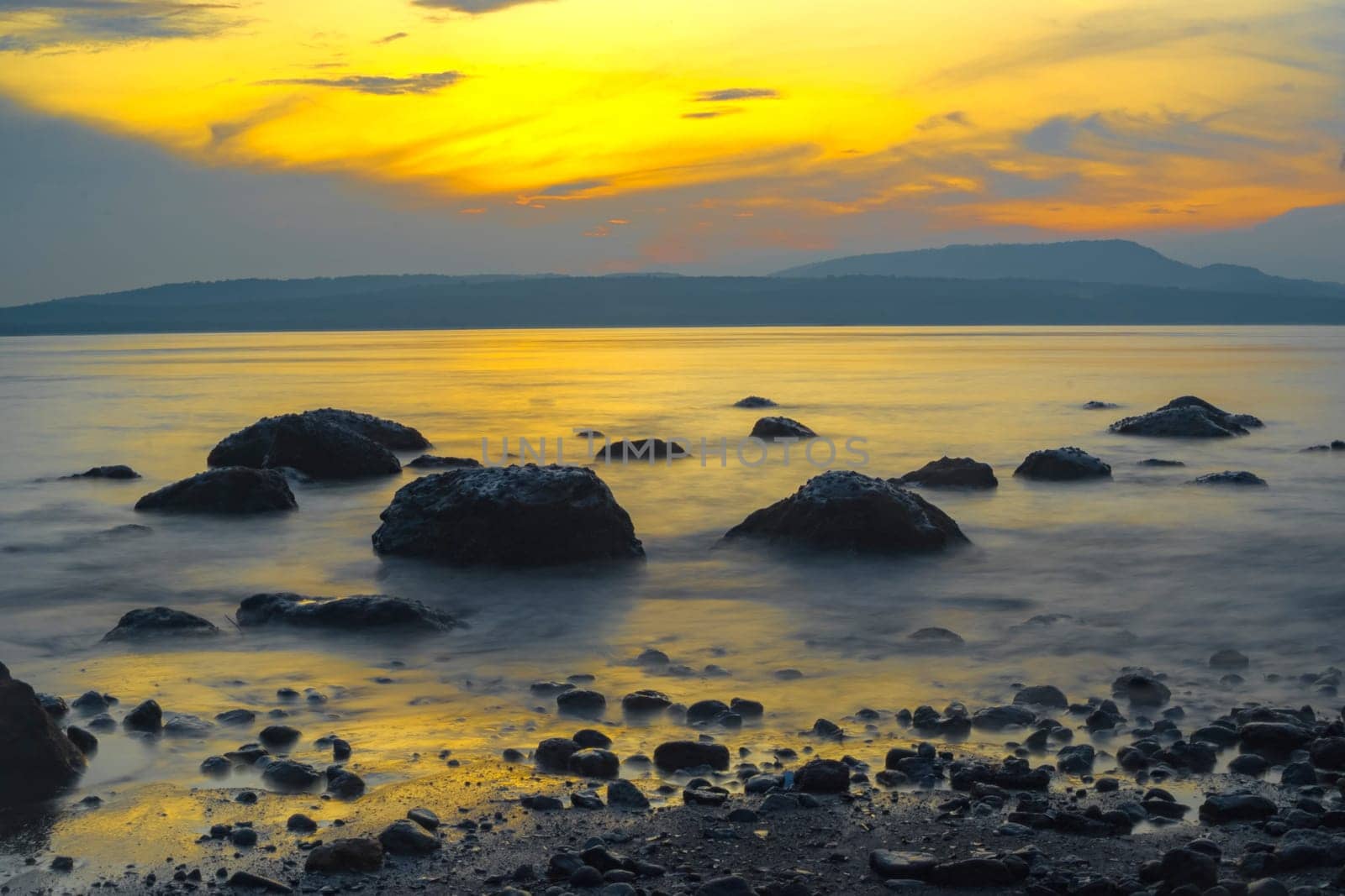Rocks on the beach during sunrise in Banyuwangi, Indonesia. Long exposure photography. Defocused.