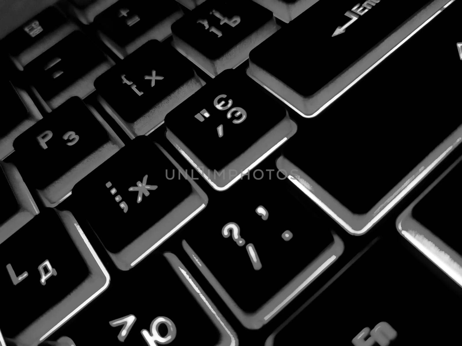 Computer keyboard black and white backlit close up.