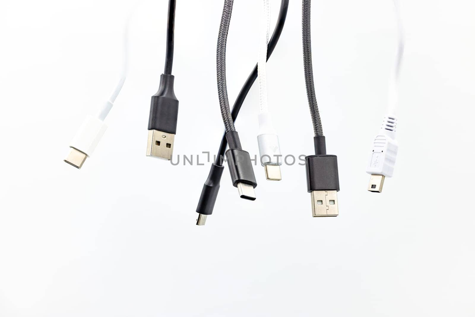 Chaos with different USB type plugs and standards isolated in the studio against a white background