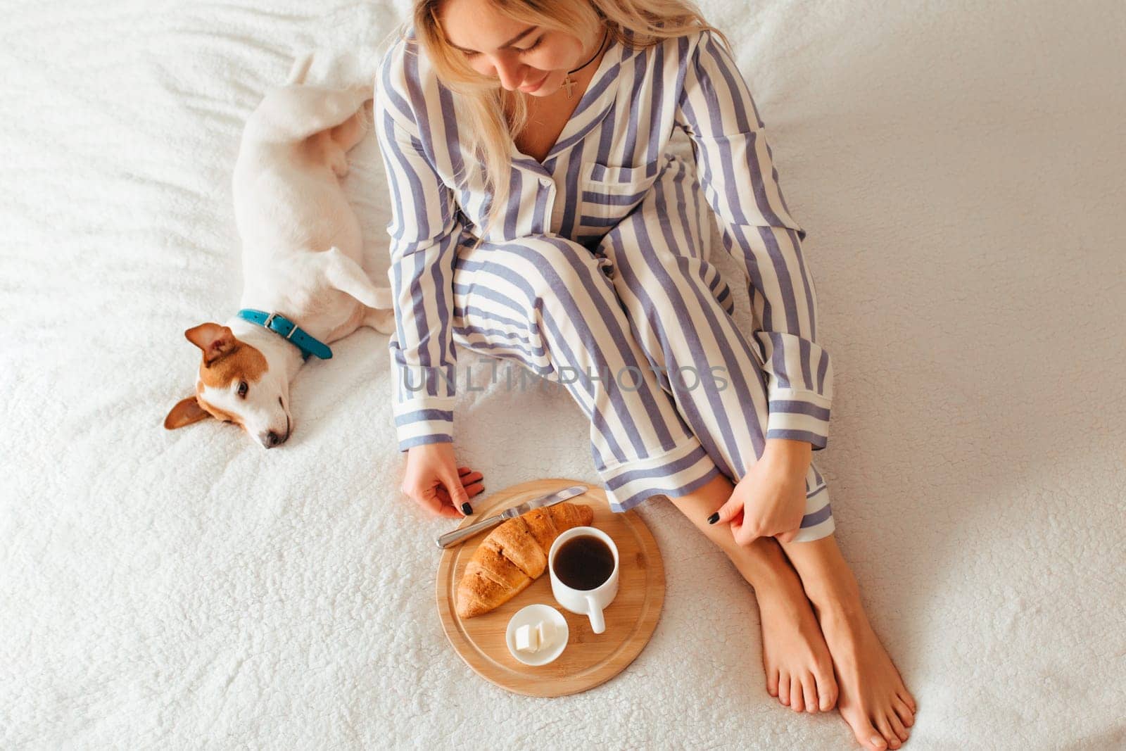 morning breakfast in bed croissant and coffee. next to her is a woman in pajamas . top view
