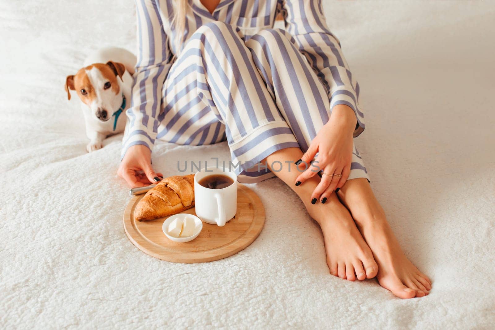 morning breakfast in bed croissant and coffee. next to her is a woman in pajamas . top view
